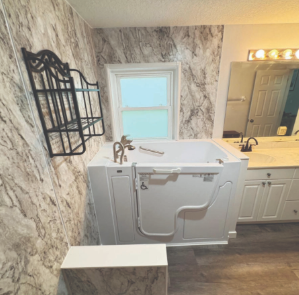 Low-threshold walk-in bathtub installed in a bathroom with marble walls