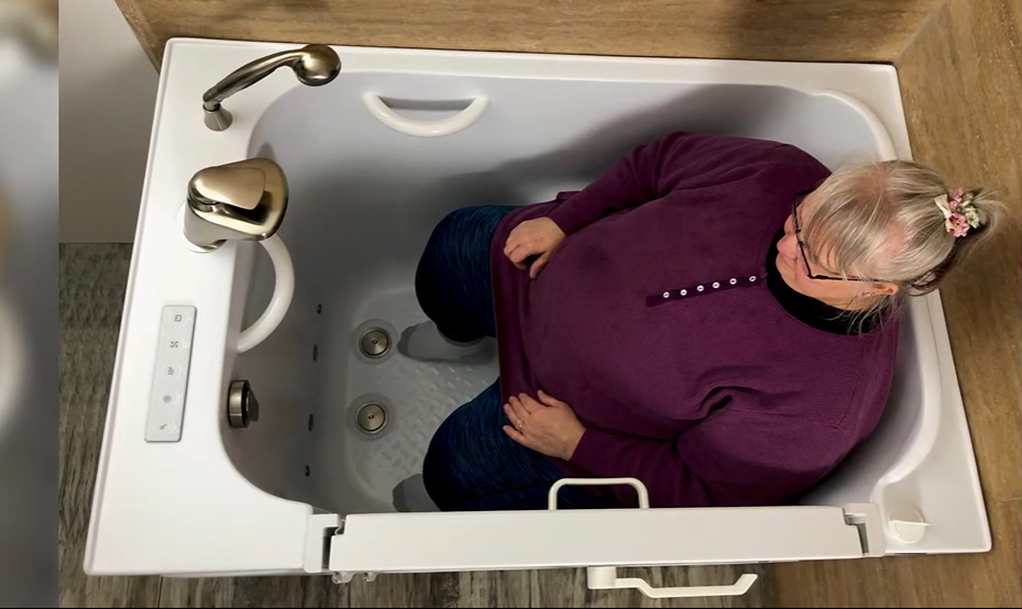 Senior woman safely seated inside a walk-in tub demonstrating aging-in-place bathroom solution